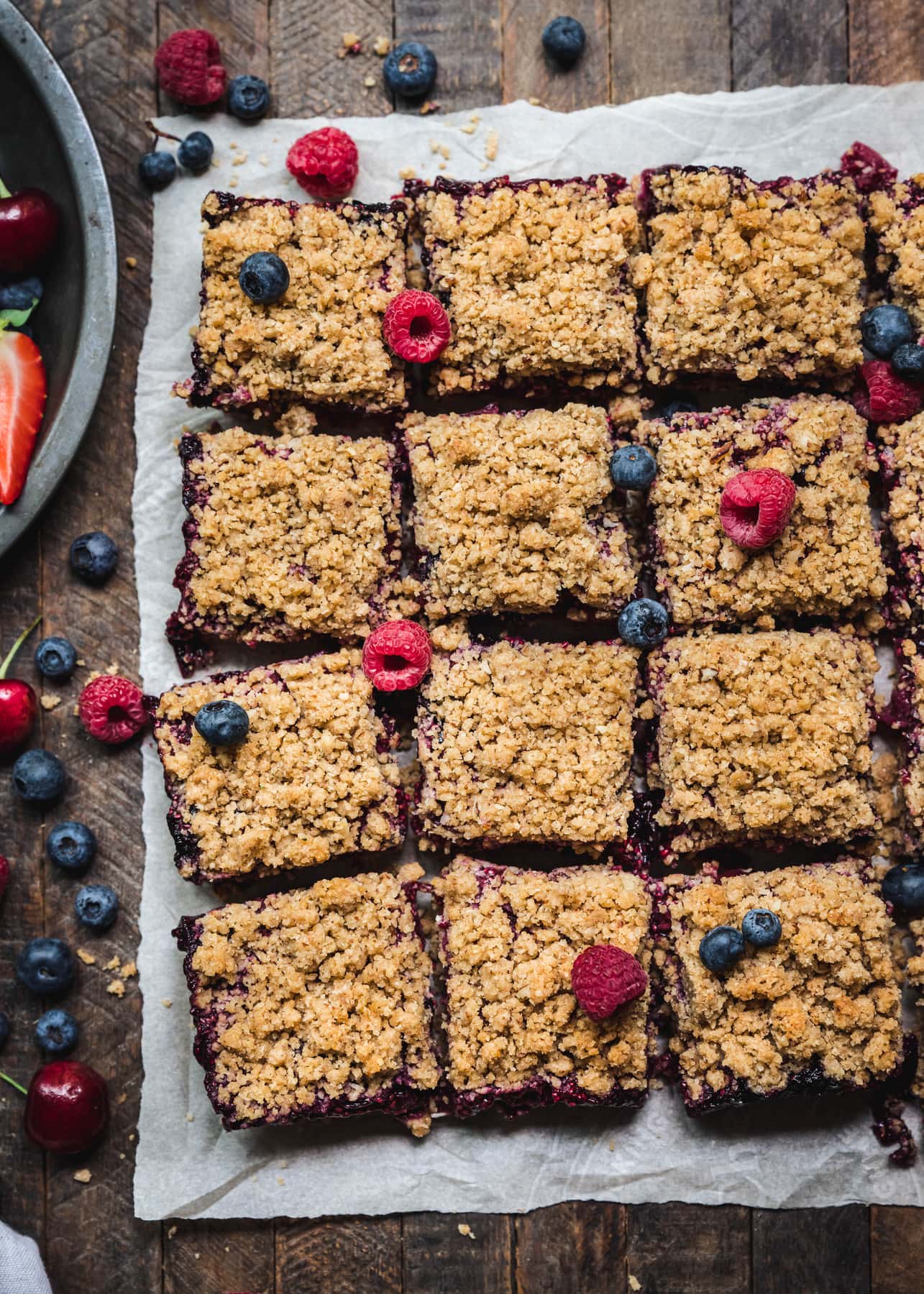 overhead of vegan four berry pie bars cut into squares on a baking sheet