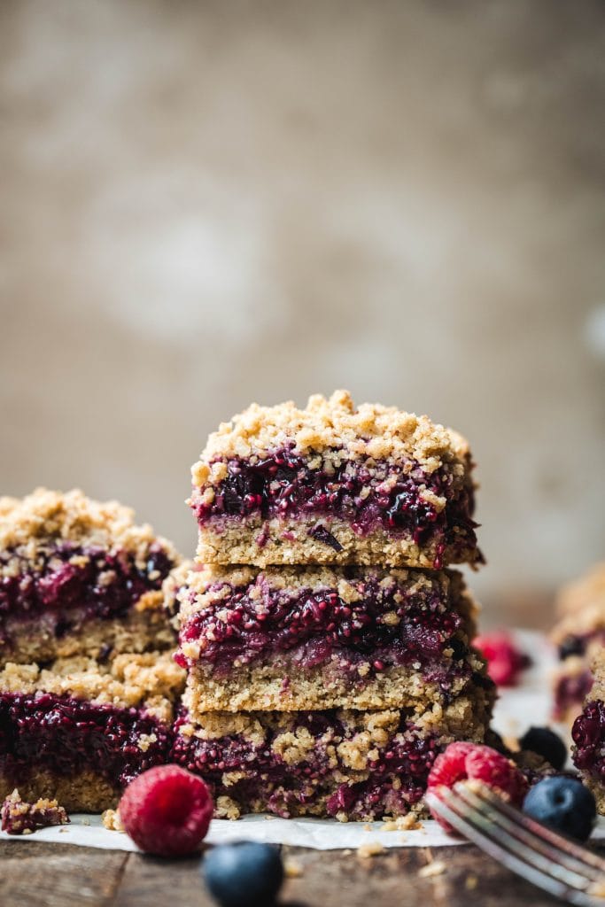 stack of gluten free four berry pie bars with fresh berries