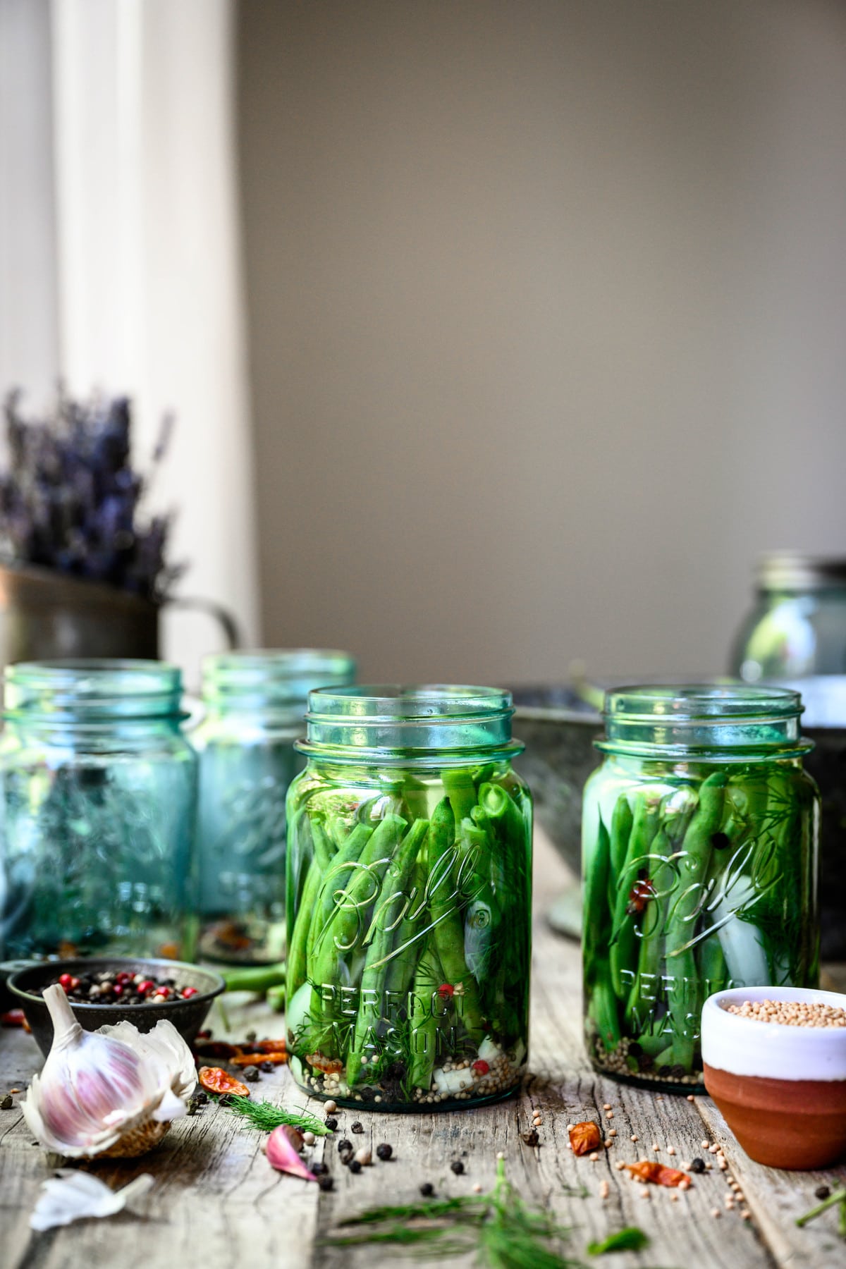 Side view of spicy pickled dilly beans in blue Ball jar