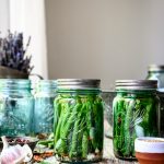 Side view of spicy pickled dilly beans in blue Ball jar
