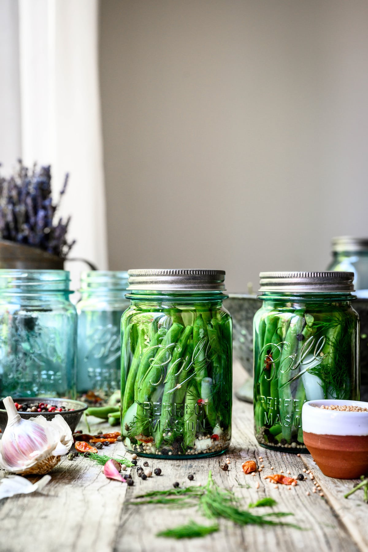 Side view of spicy pickled dilly beans in blue Ball jar