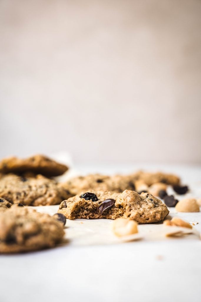 Side view of chocolate chip cherry cookies with macadamia nuts on white background