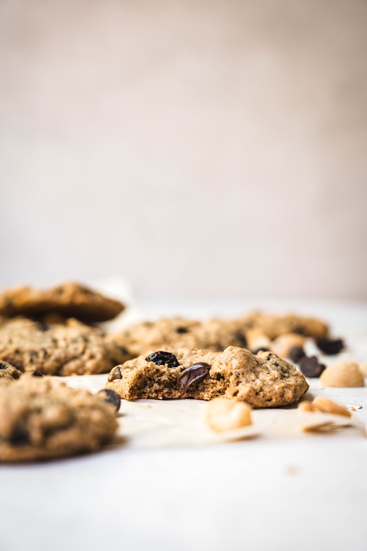 Side view of chocolate chip cherry cookies with macadamia nuts on white background