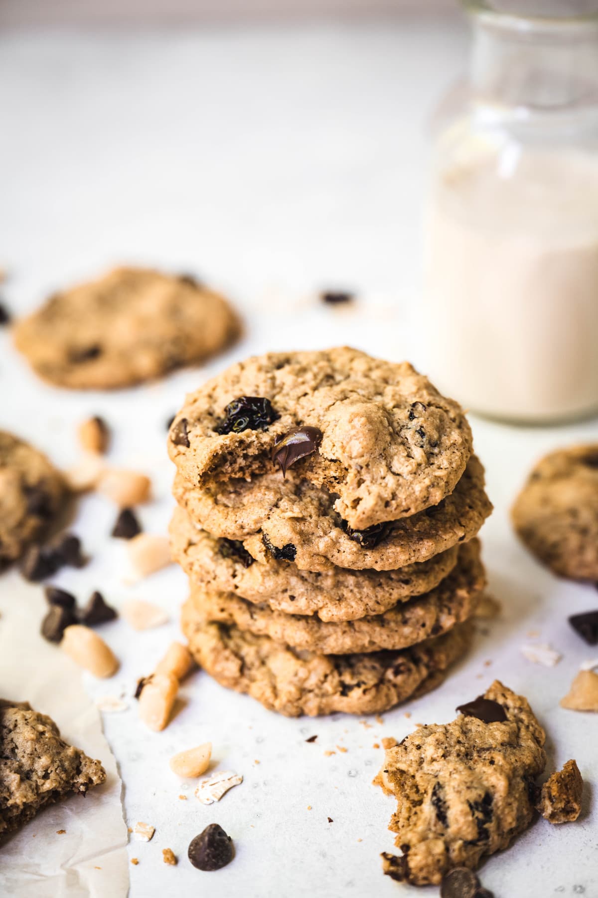 Side view of stack of chocolate chip cherry cookies with macadamia nuts with milk in background