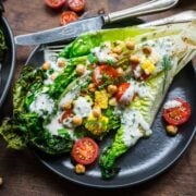 Overhead view of grilled romaine with tomatoes and ranch dressing.