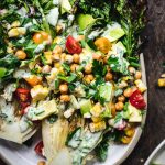 overhead of grilled romaine salad with vegan ranch, crispy chickpeas, grilled corn and avocado