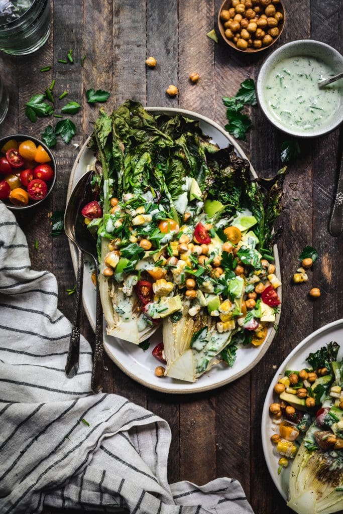 Overhead of grilled romaine salad with grilled corn, avocado, tomato and crispy chickpeas