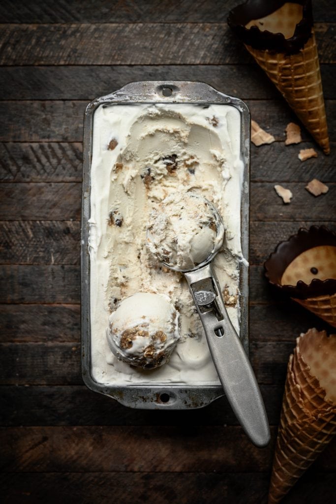 Overhead view of vegan cookie dough ice cream in antique pan with scoop