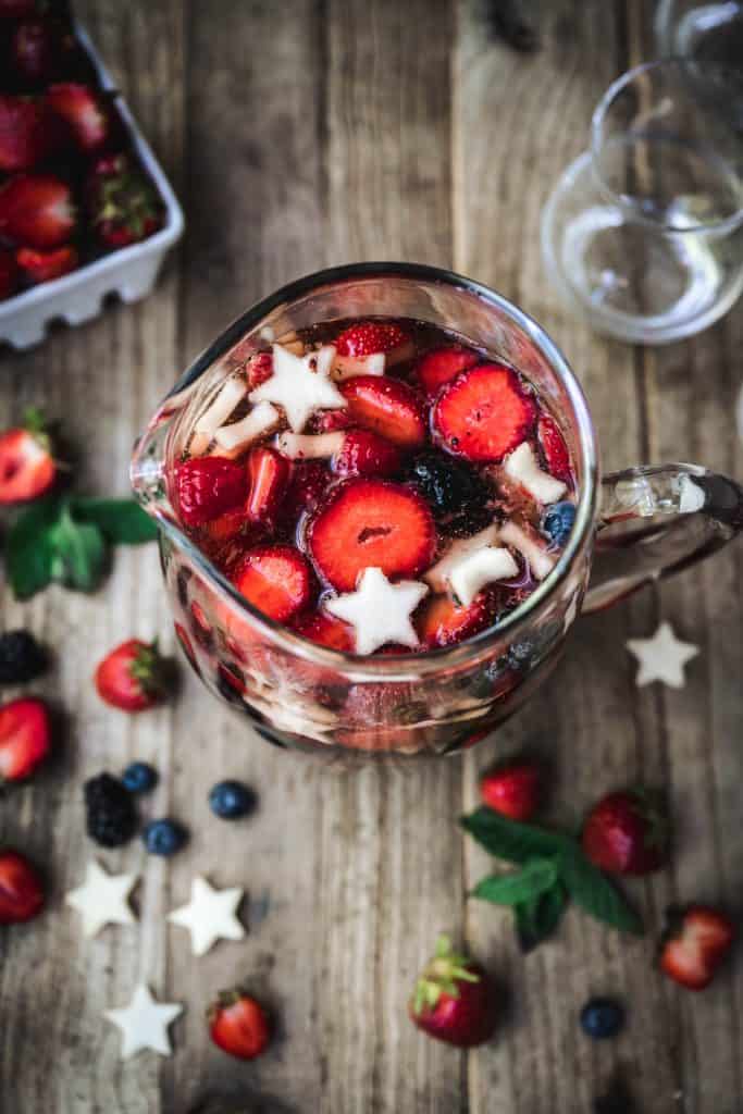 overhead of red white and blue sangria with berries in a pitcher