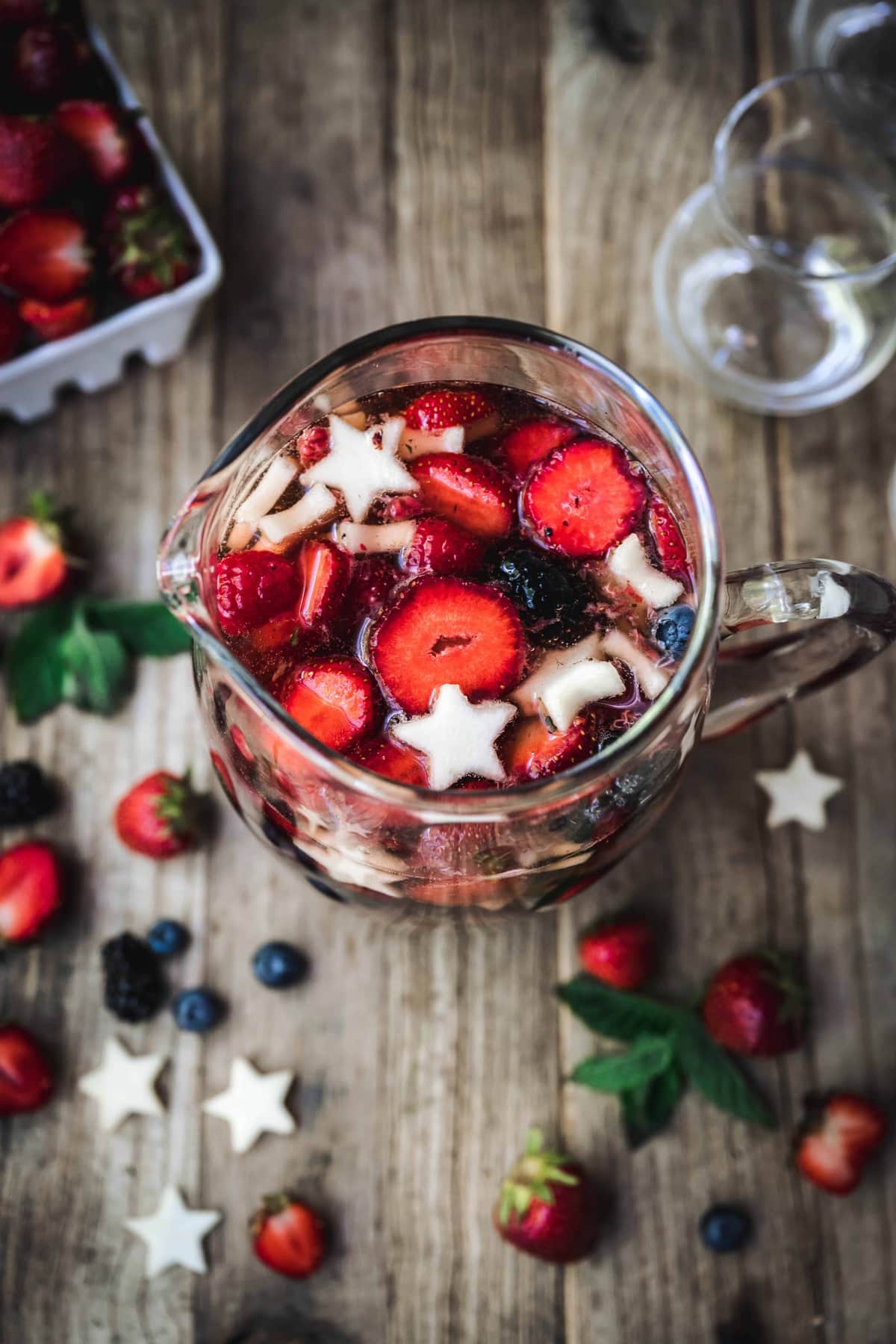 overhead of red white and blue sangria with berries in a pitcher