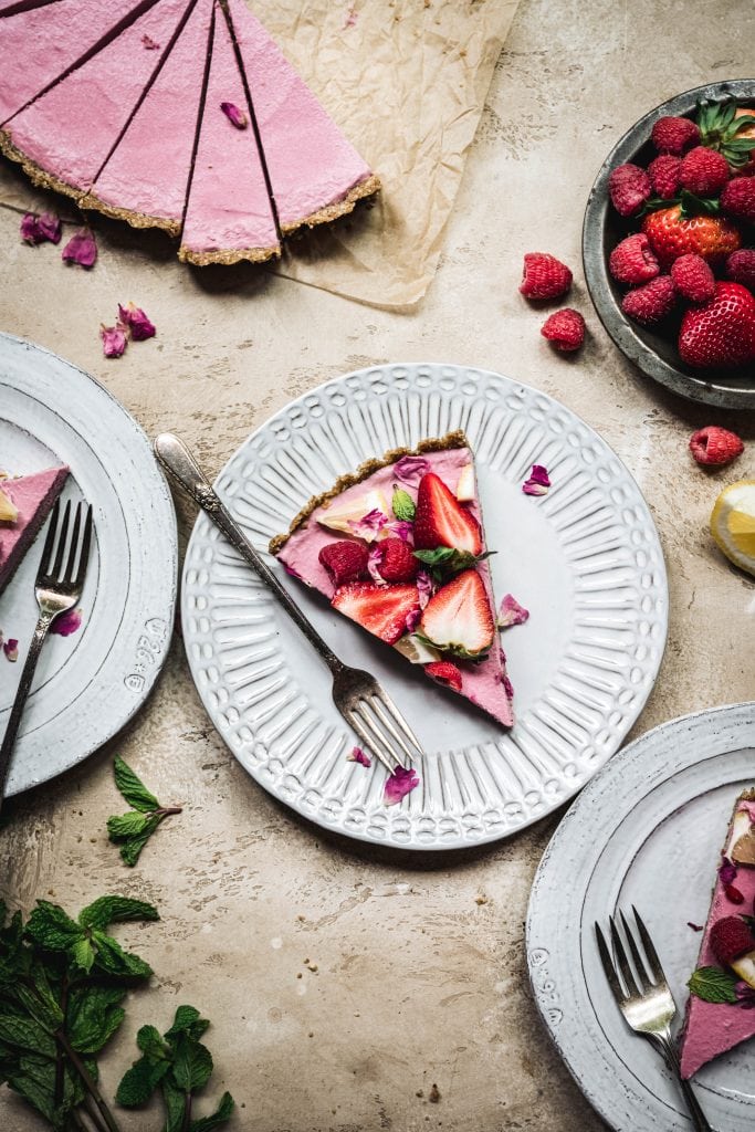 Overhead view of slice of vegan strawberry mousse pie on a white plate
