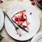 Overhead view of slice of vegan strawberry mousse pie on a white plate