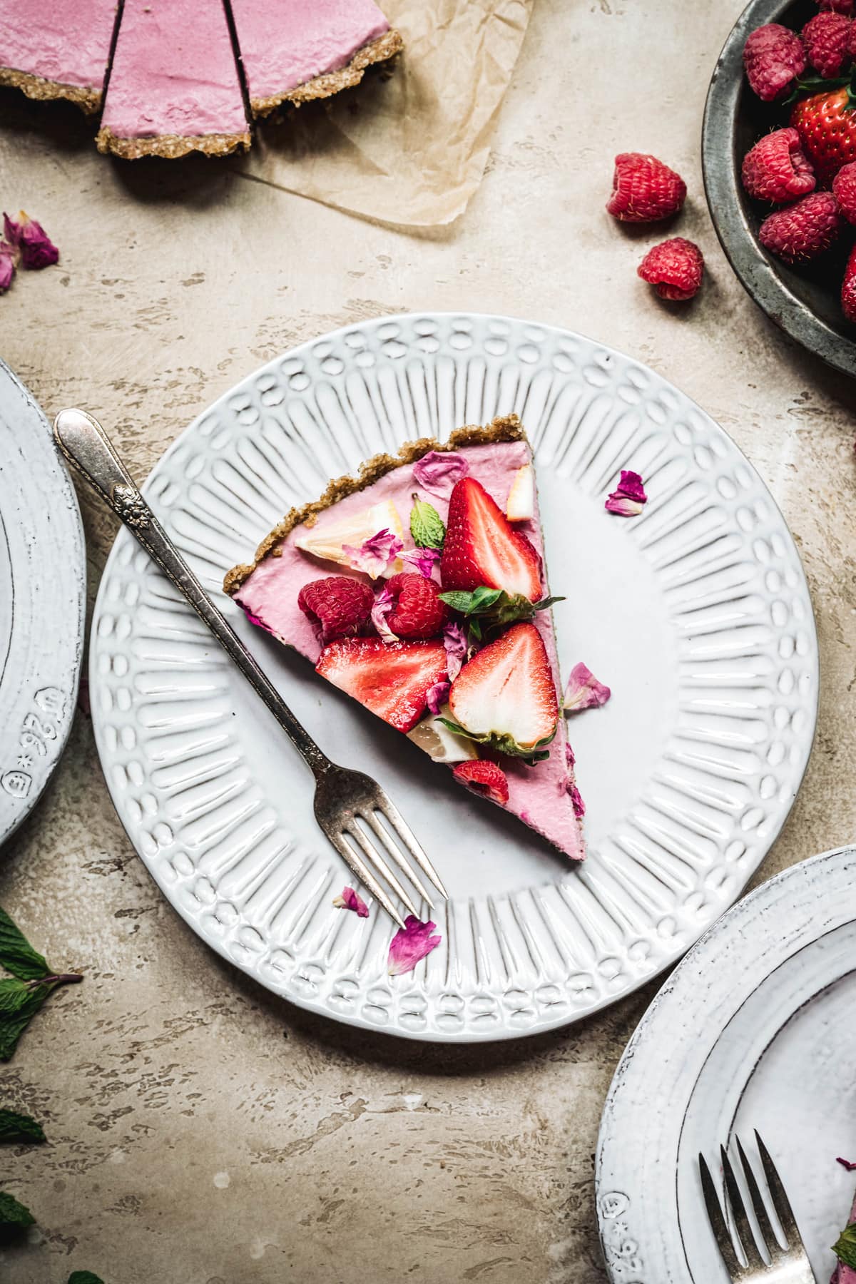 Overhead view of slice of vegan strawberry mousse pie on a white plate