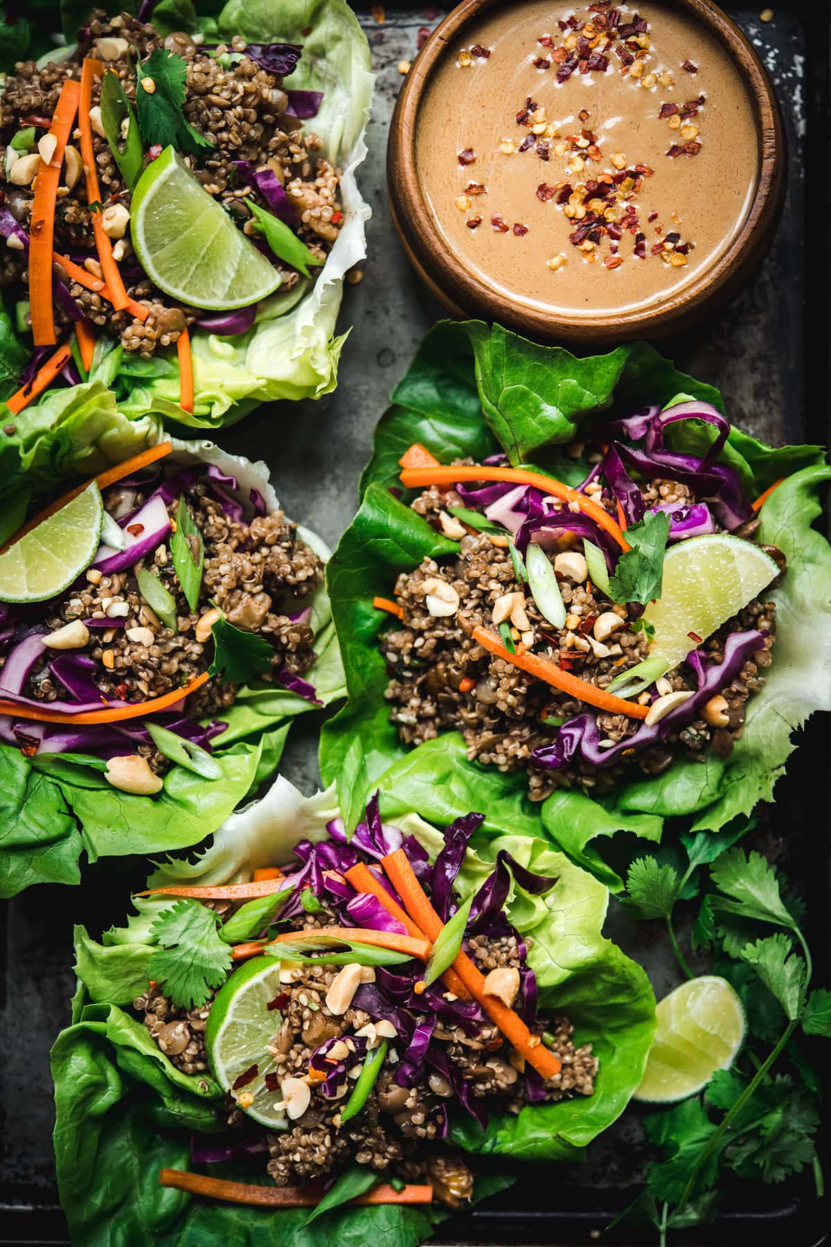 Close up Overhead view of vegan asian lettuce wraps with lentil walnut filling and peanut sauce on antique tray