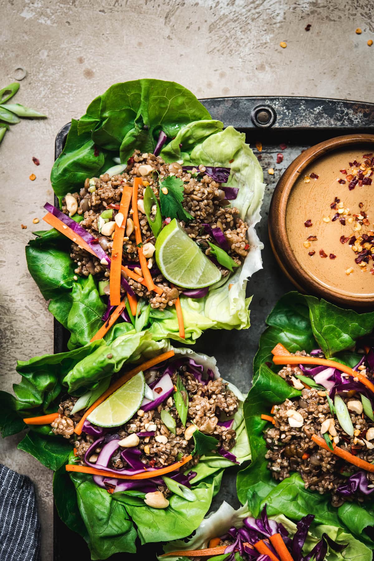 Close up Overhead view of vegan asian lettuce wraps with lentil walnut filling and peanut sauce on antique tray