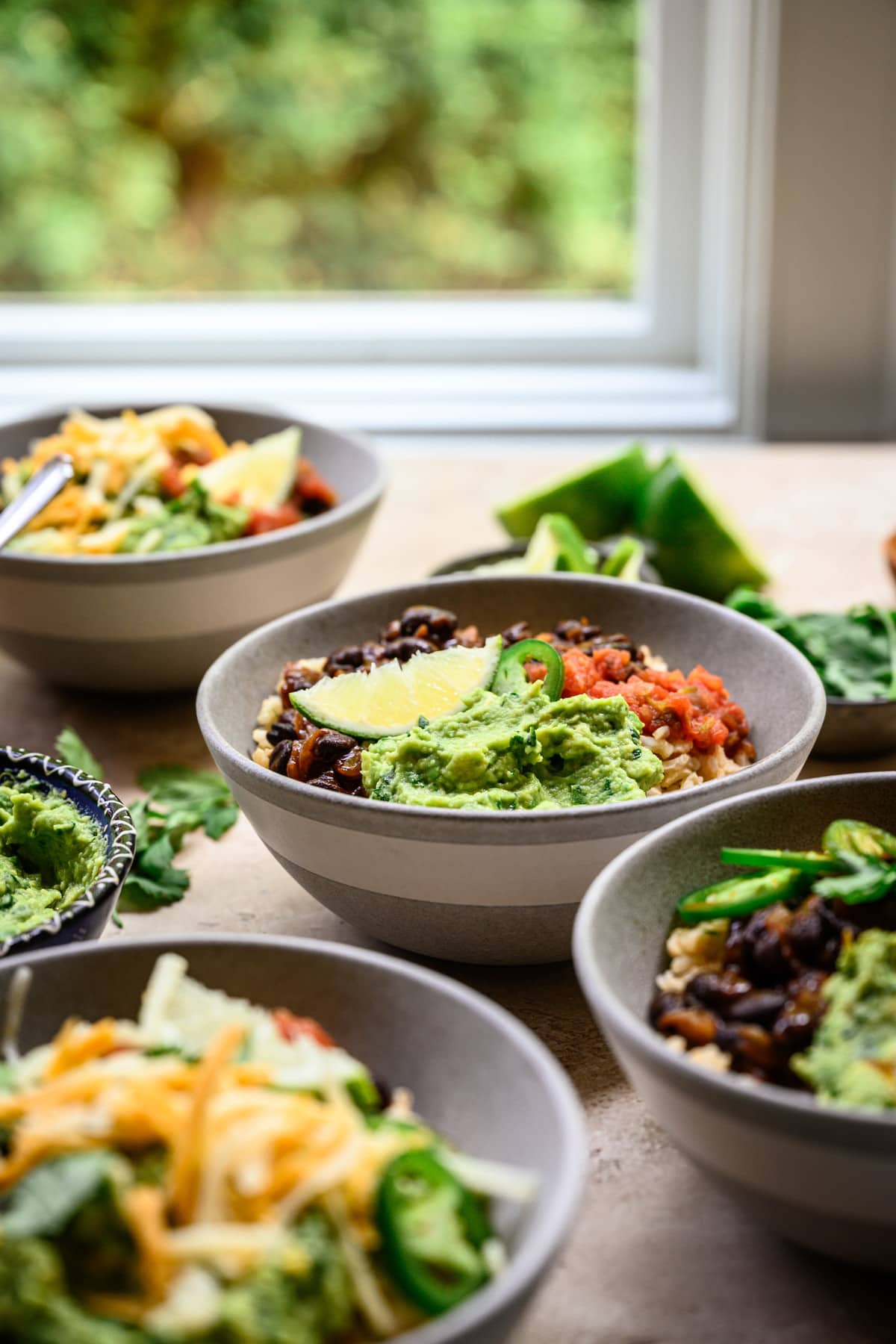 Side view of vegan burrito bowls with window in background