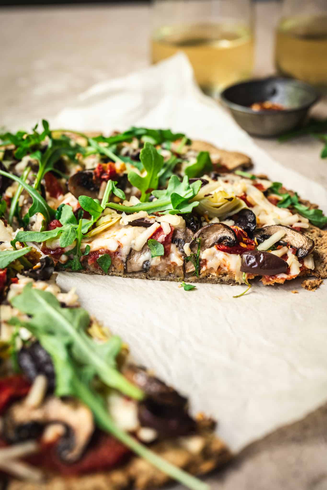 Side view of slice of vegan cauliflower crust pizza