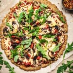 Overhead view of Crispy Cauliflower Vegan Pizza Crust with vegan pizza toppings on rustic background with white wine