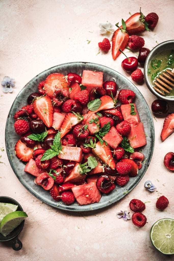 Overhead of watermelon berry salad with mint lime dressing in a blue bowl