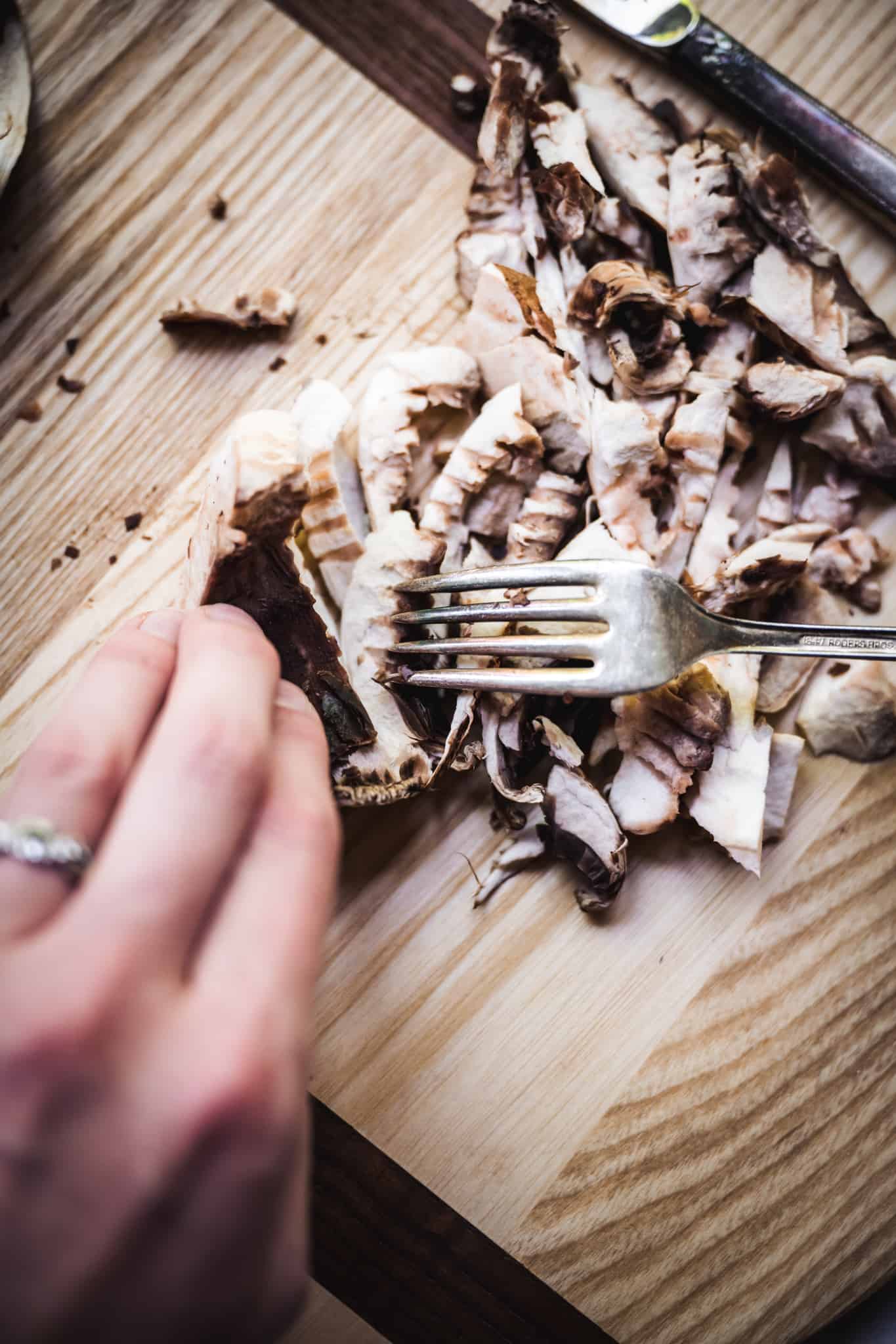 Person shredding portobello mushrooms