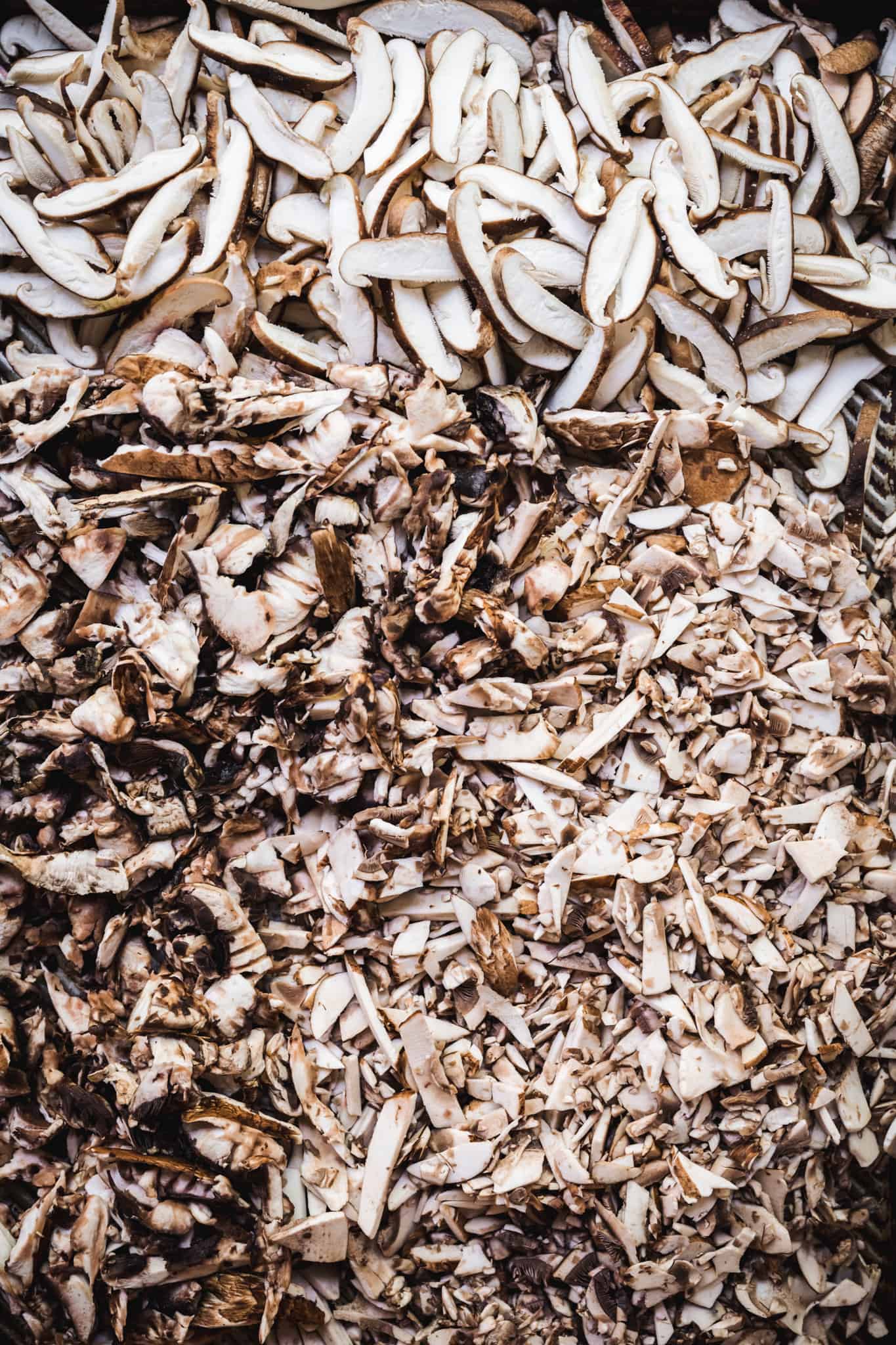 Overhead view of sliced mushrooms on a sheet pan