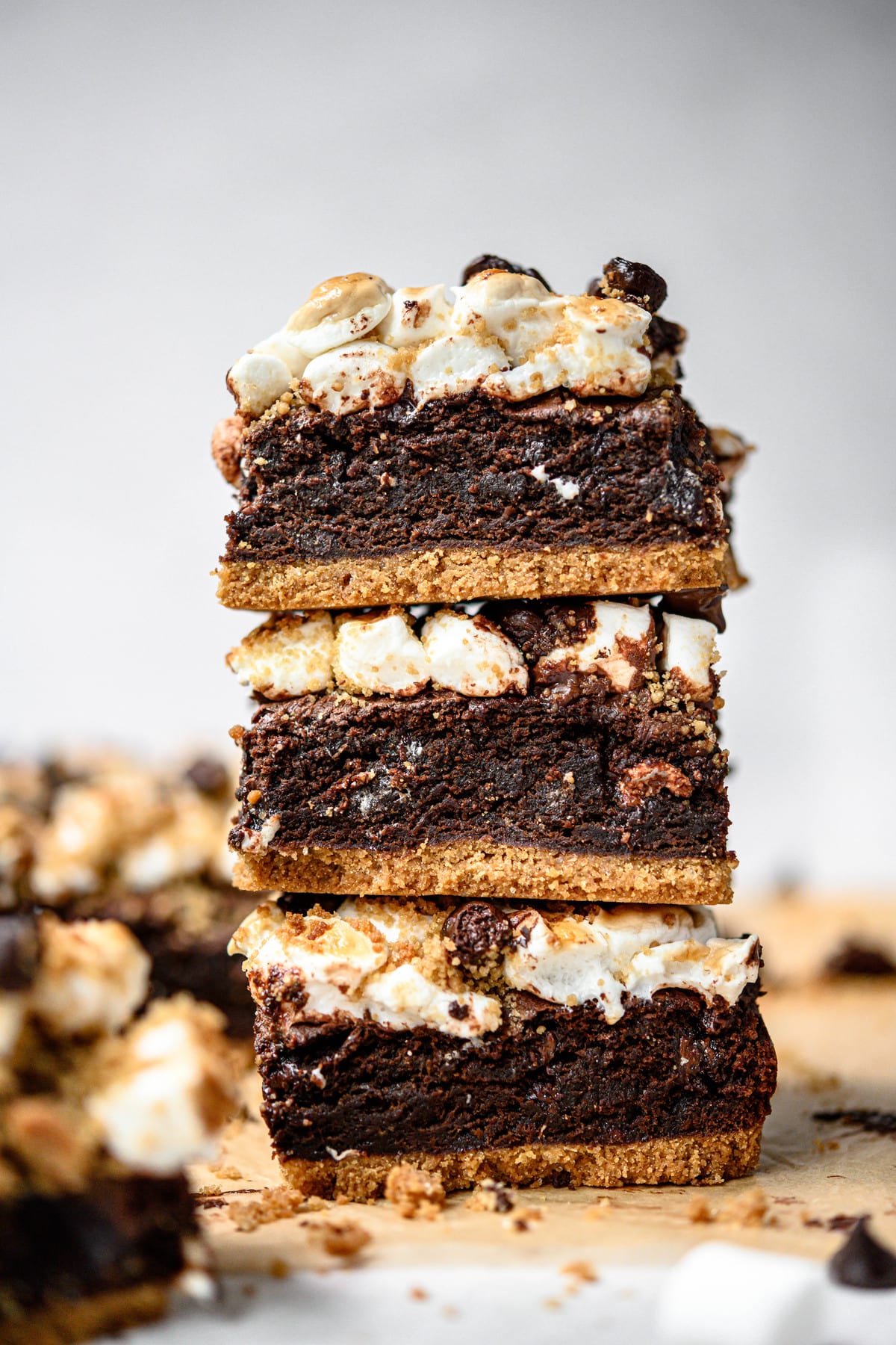 Close up Side view of three stacked vegan and gluten free s'mores brownies on parchment paper