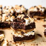Side view of two stacked vegan and gluten free s'mores brownies on parchment paper