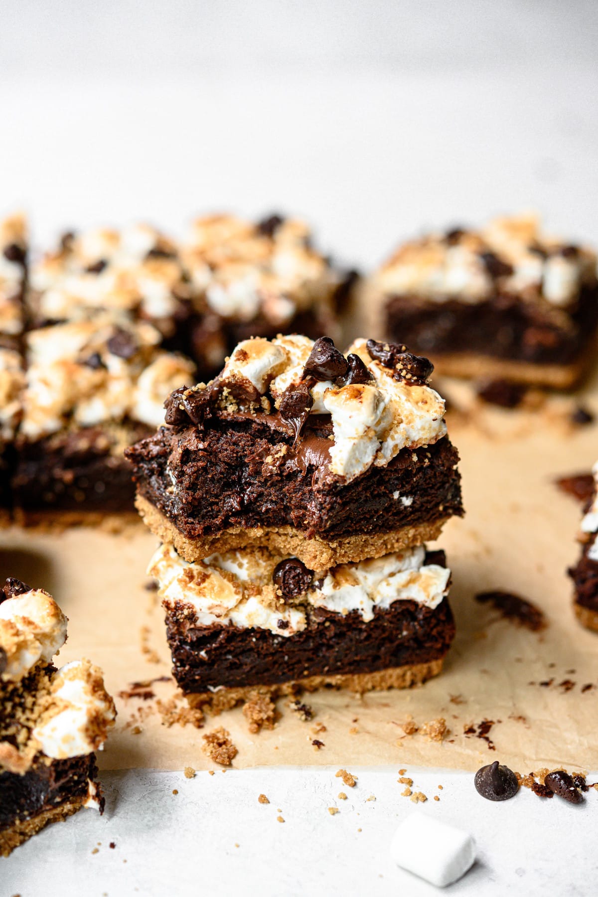 Side view of two stacked vegan and gluten free s'mores brownies on parchment paper