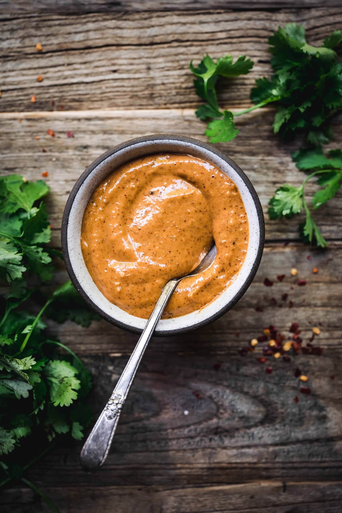 Overhead view of red curry almond butter sauce in small ceramic bowl