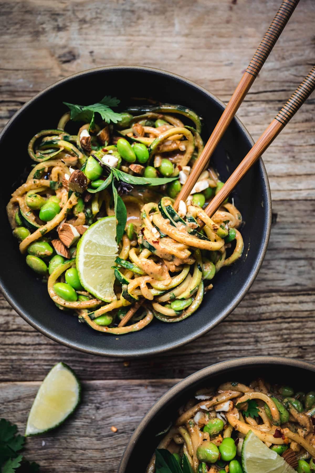 Overhead of red curry almond butter zucchini noodles in a bowl with chocpsticks