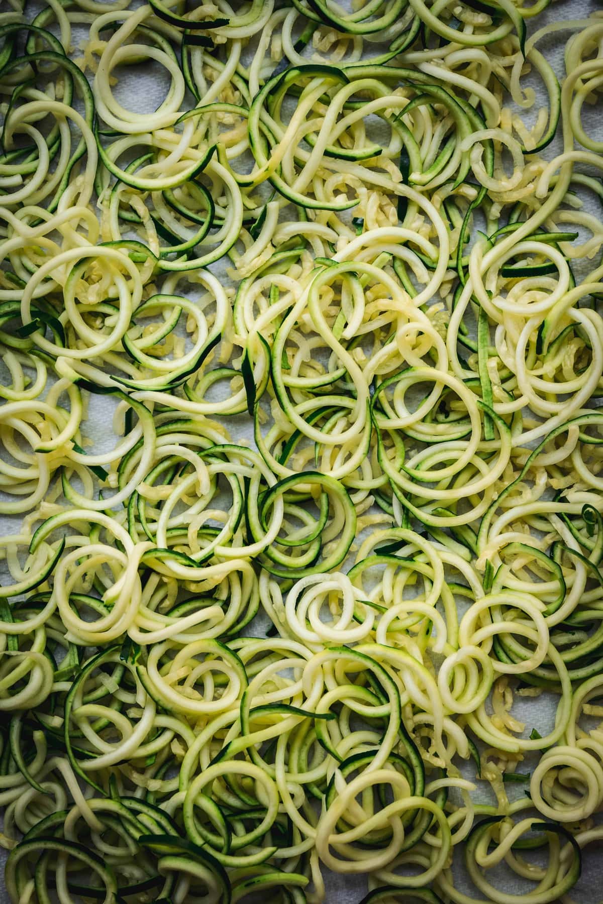 Overhead view of spiralized zucchini noodles on sheet pan