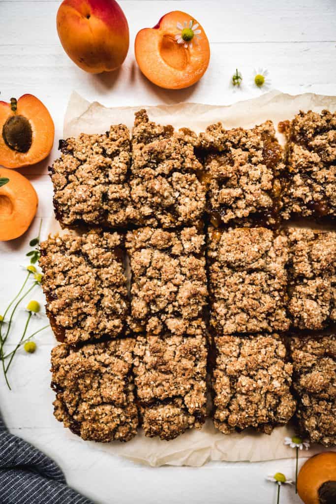 overhead view of vegan apricot oat bars on a white surface