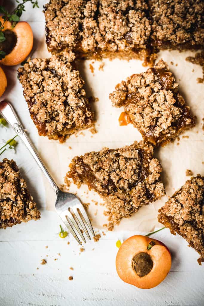Overhead view of sliced vegan apricot oat bars on parchment paper