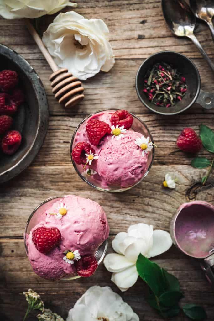 Overhead view of raspberry green tea infused ice cream in small glass jars on wood table