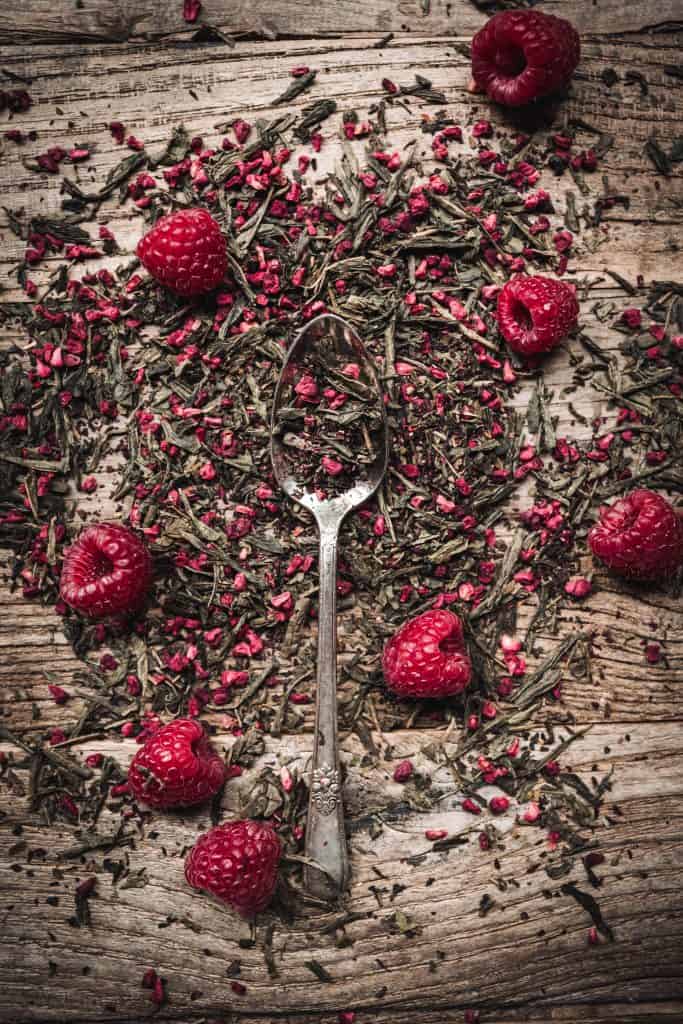 Overhead view of loose leaf raspberry green tea on a wood table