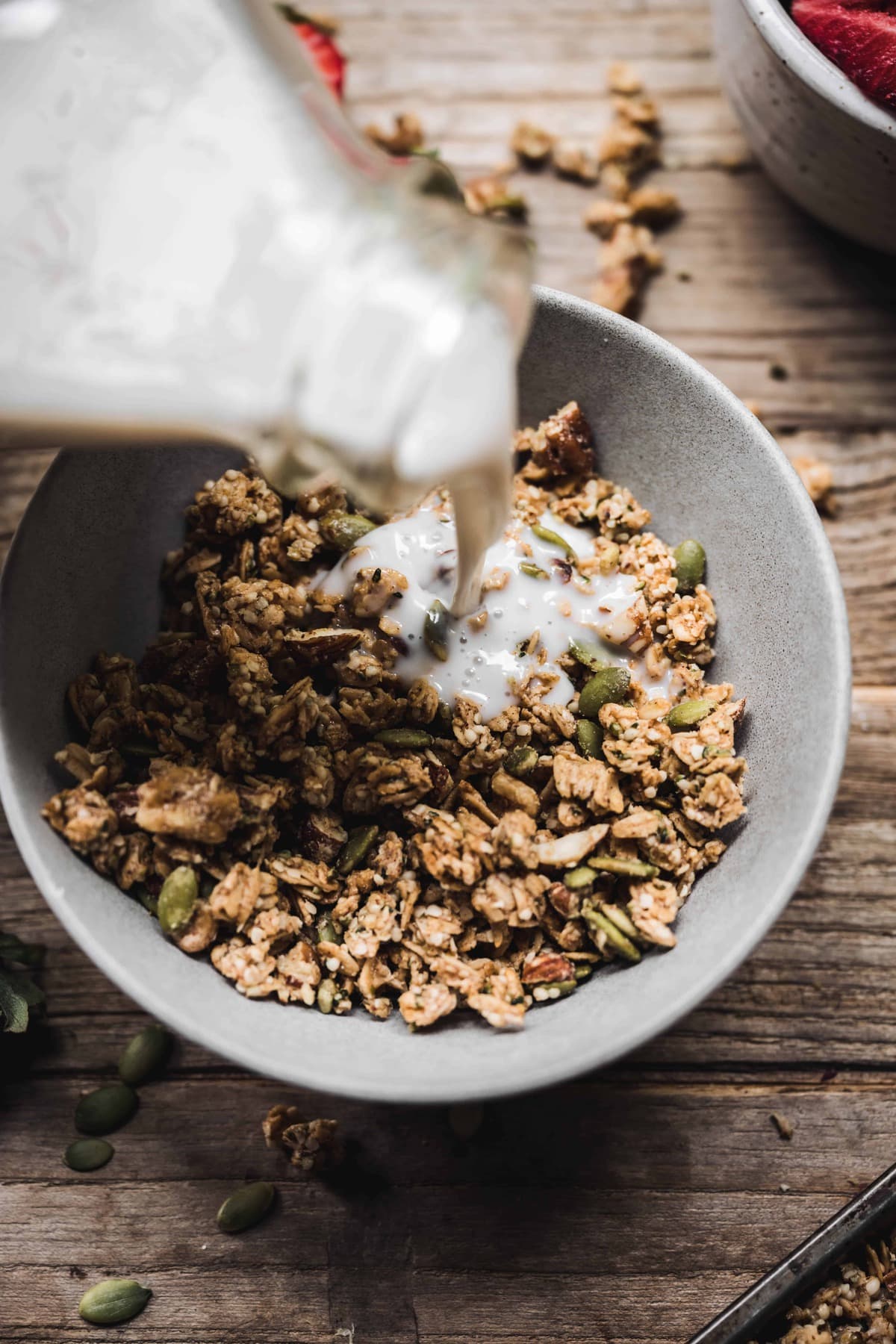 Close up of pouring milk into a bowl of homemade granola