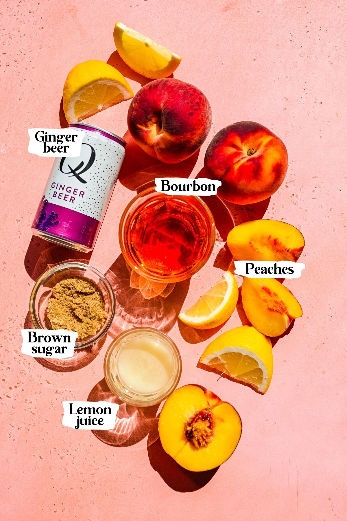 overhead view of ingredients for bourbon peach smash on pink backdrop.