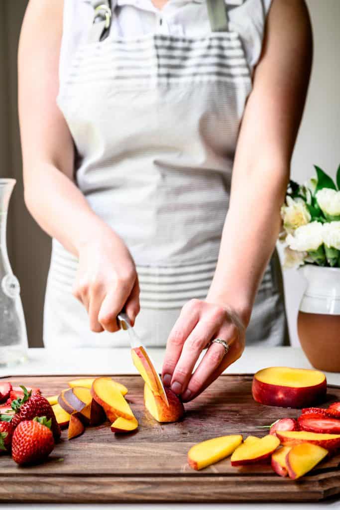 side view of person slicing fresh peaches