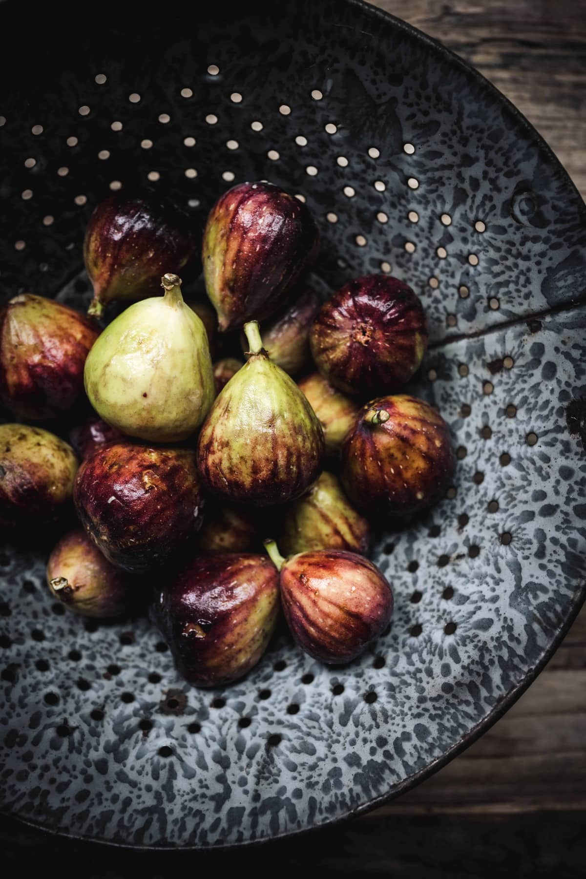 Overhead view of fresh, whole figs in colander