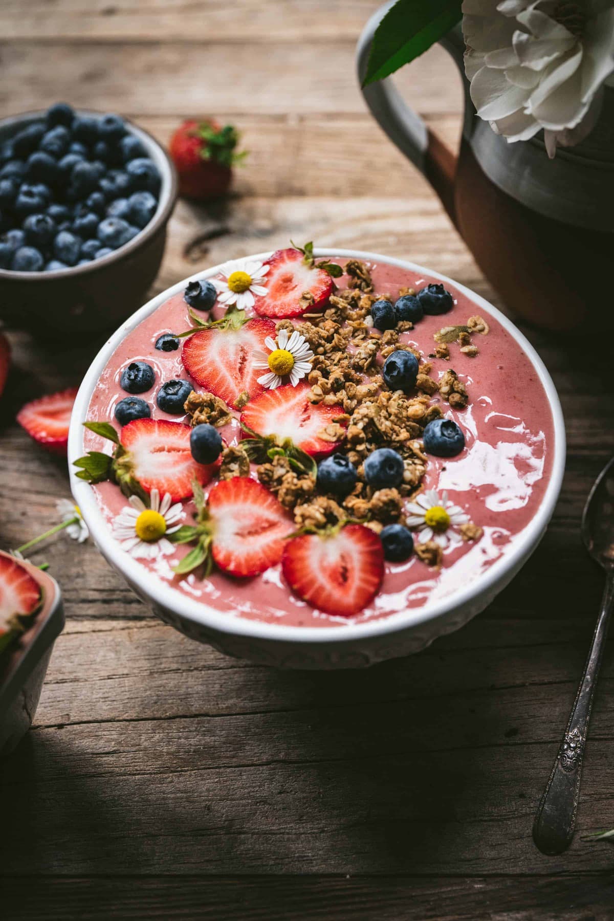 side view of vegan strawberry smoothie bowl on wood table