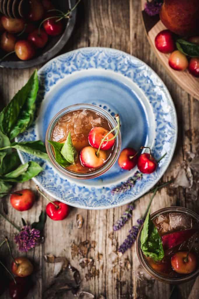 overhead view of peach basil cocktail on blue plate