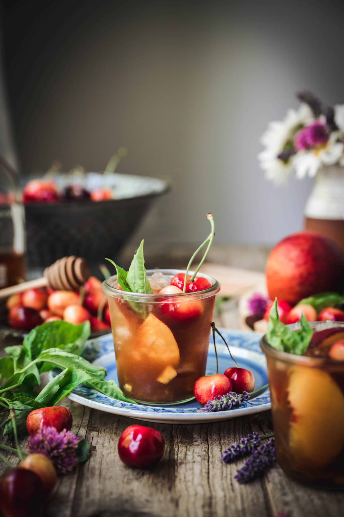 side view of bourbon peach smash cocktail on wood table