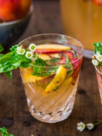 Glass of strawberry peach sangria garnished with fruit.