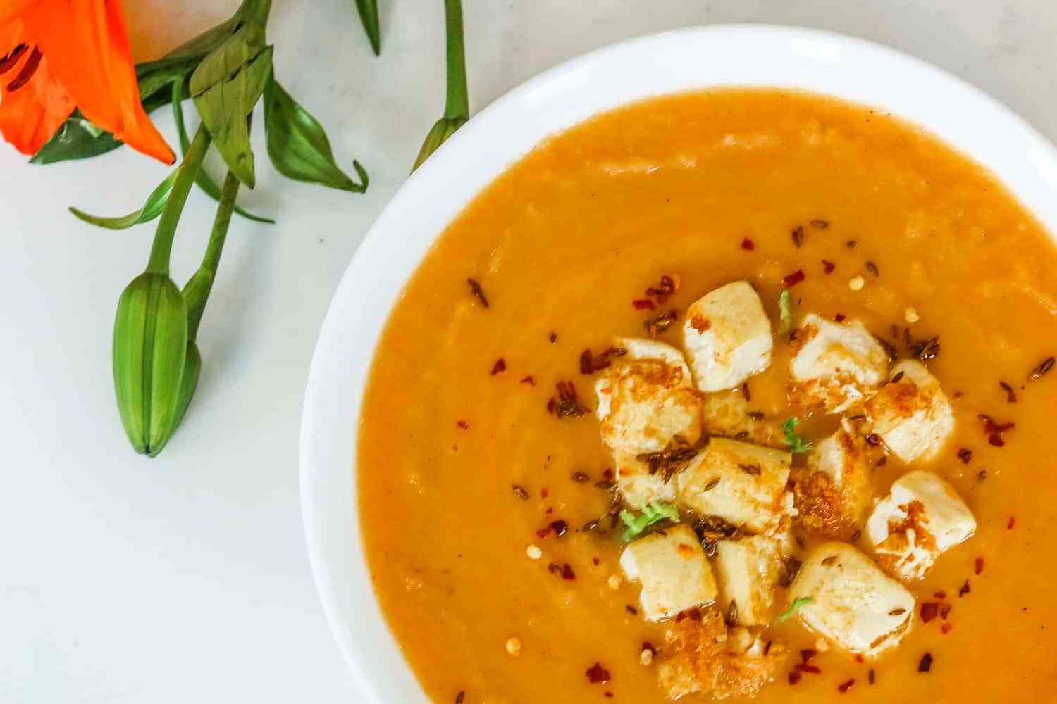 overhead of vegan tomato and fennel soup topped with crispy tofu