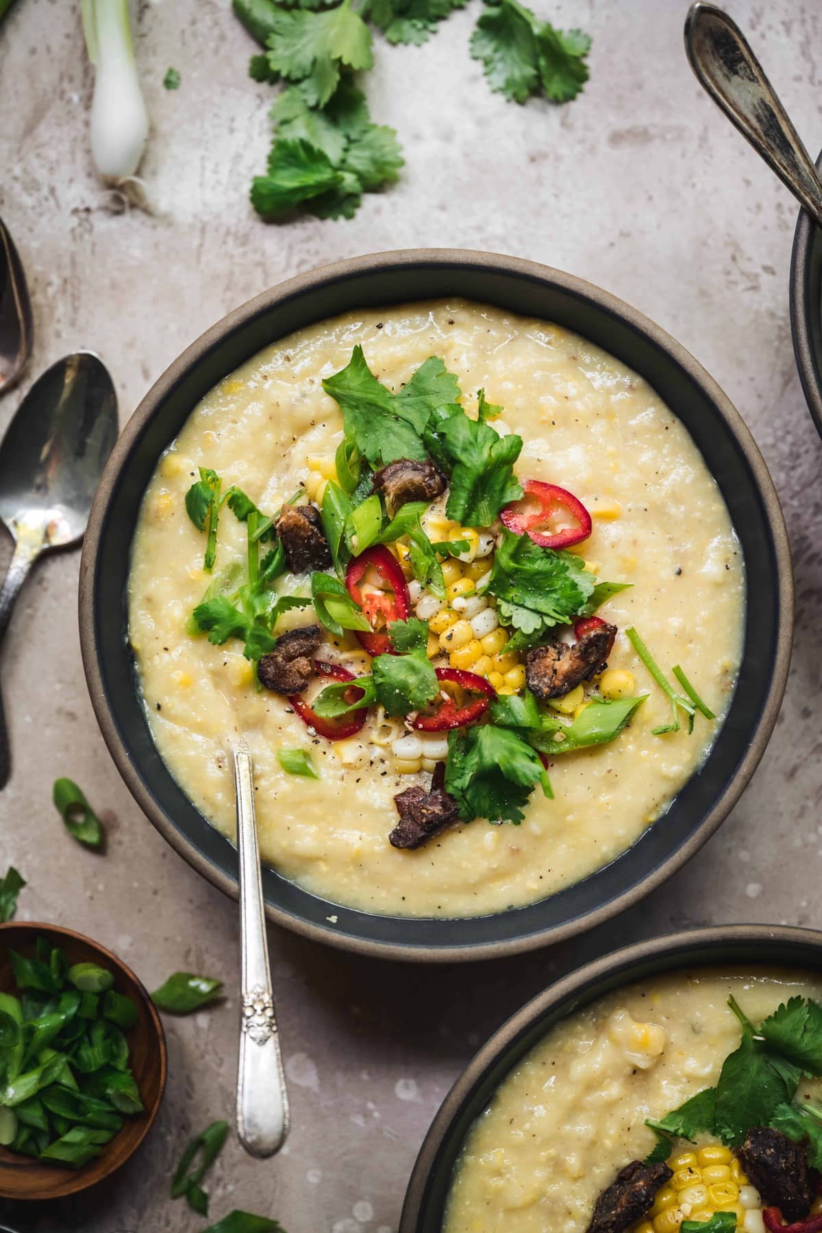 overhead of vegan coocnut corn chowder with crispy dates and fresh herbs