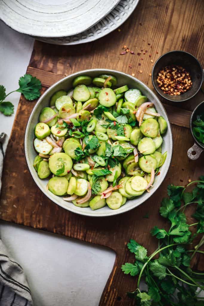 overhead of asian cucumber salad in a bowl with spices around