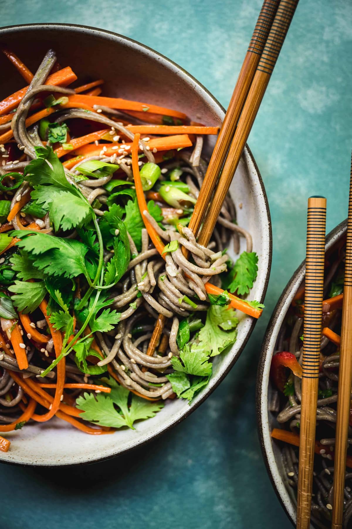 overhead of japanese soba noodle salad in a bowl with chopsticks