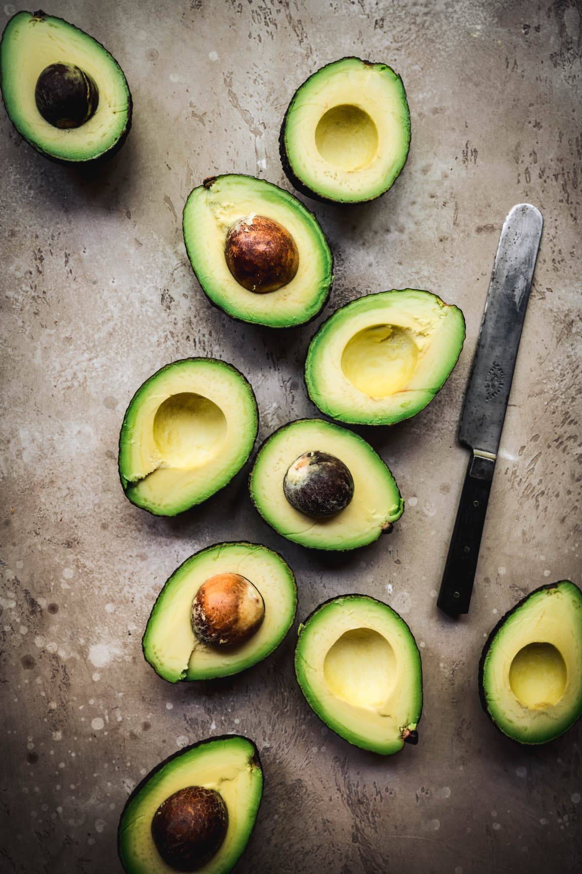 Beautiful photo of avocados sliced in half on a rustic background