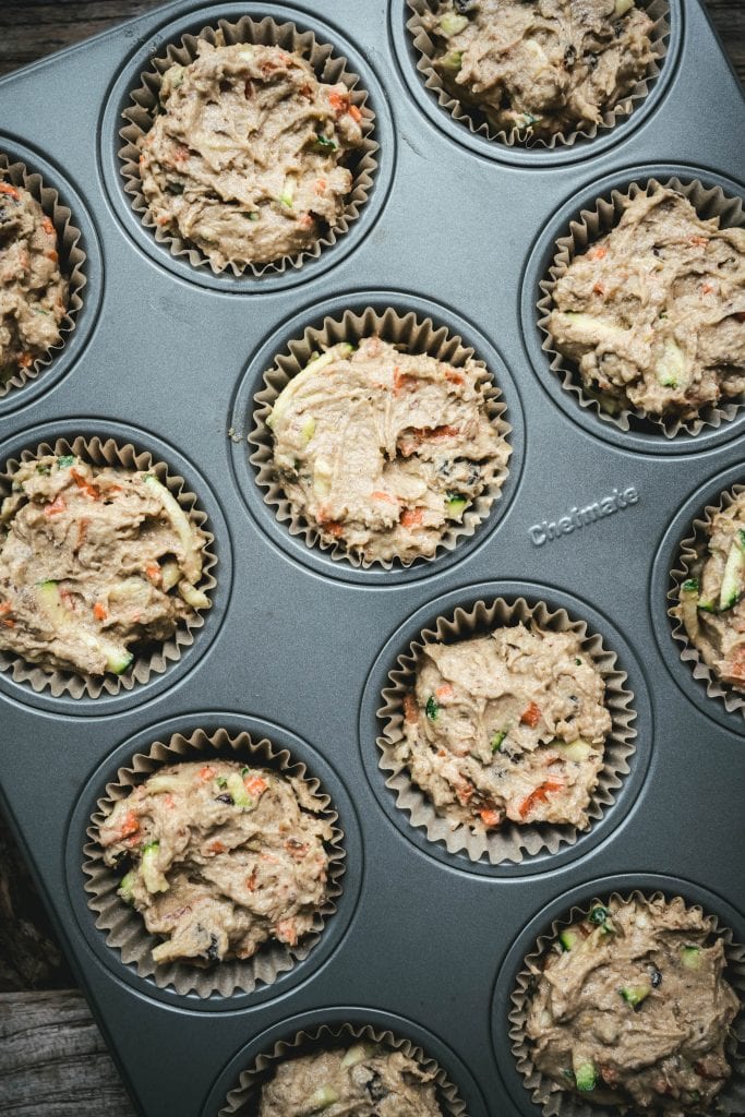 overhead of vegan zucchini muffin batter in muffin tins before it's baked