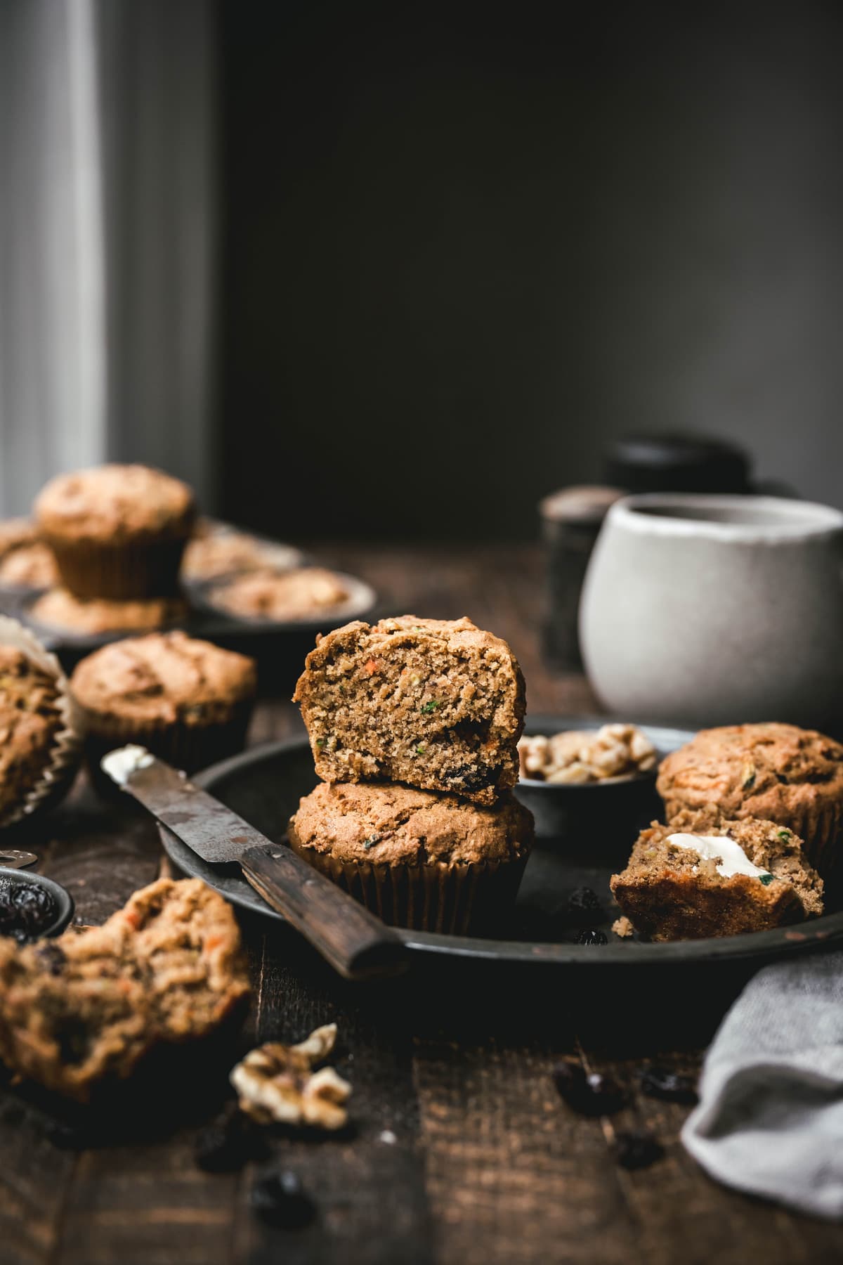 side view of a gluten free zucchini muffin cut in half on a table